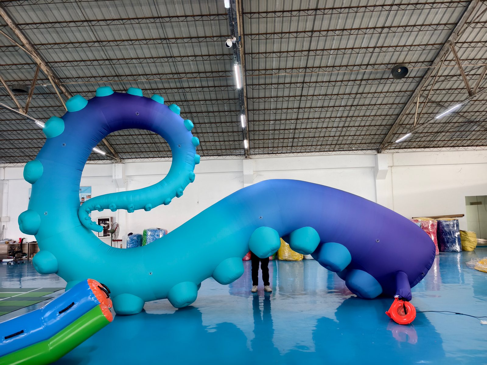 Large blue and purple inflatable octopus tentacles during a factory inflation test.